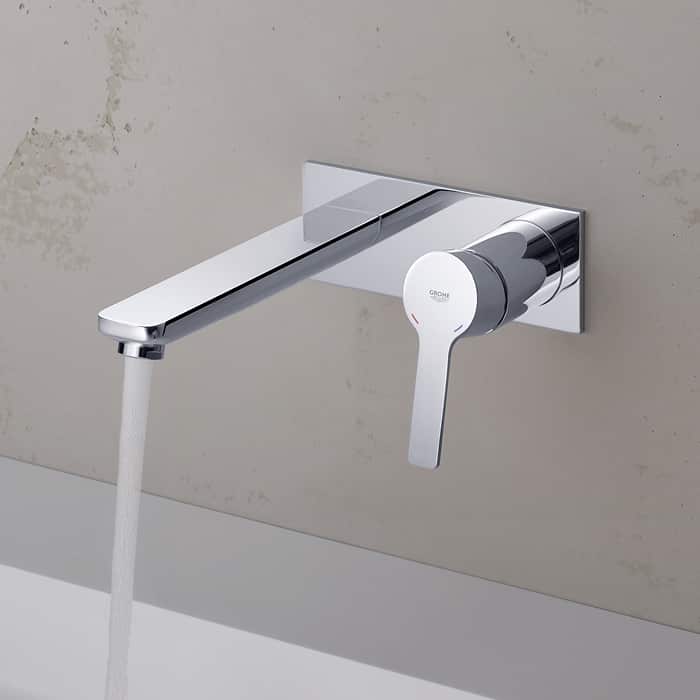 A chrome, wall-mounted basin outlet and mixer