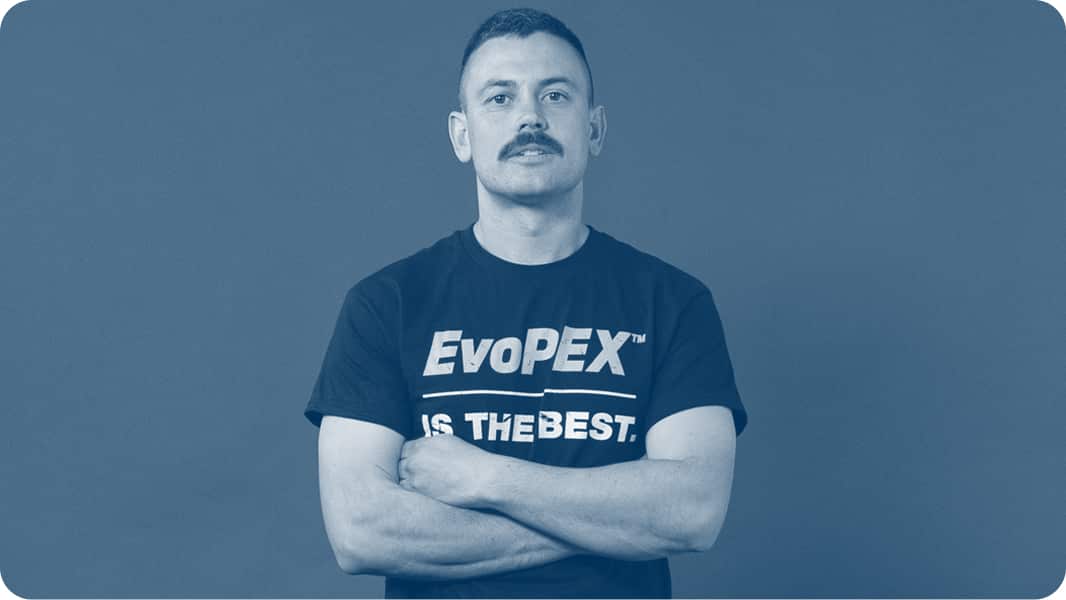 A plumber, in an Evopex t-shirt, crossing his arms and looking directly at camera.