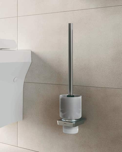 A toilet brush holder, next to a toilet