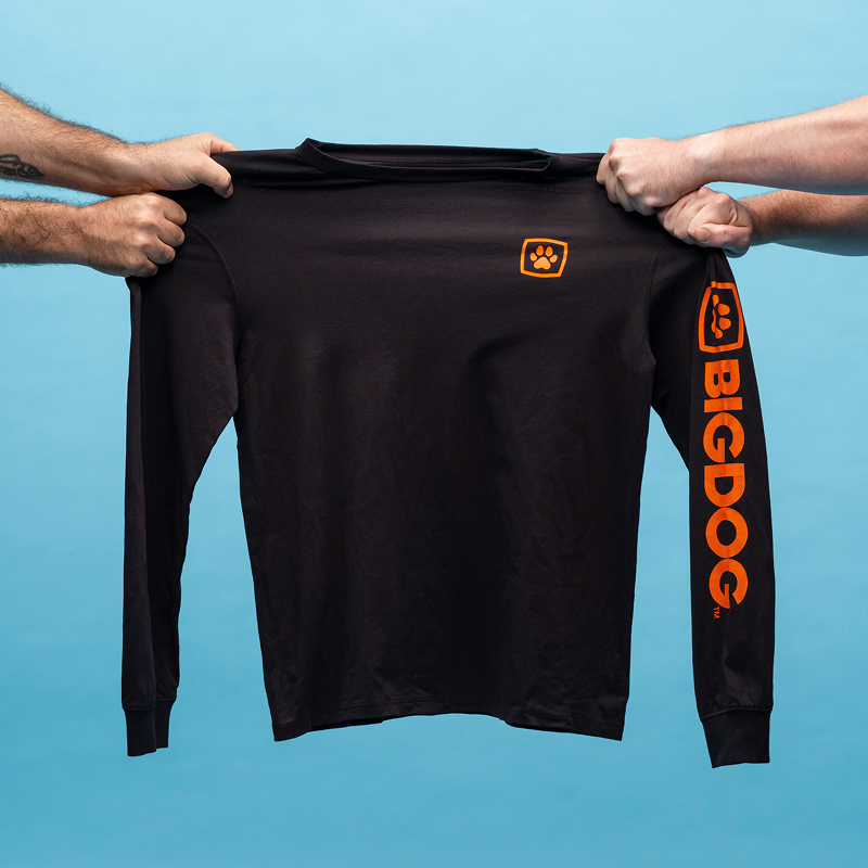 Two sets of hands pulling a black, long-sleeved BIGDOG tee from each side, stretching it in the middle.