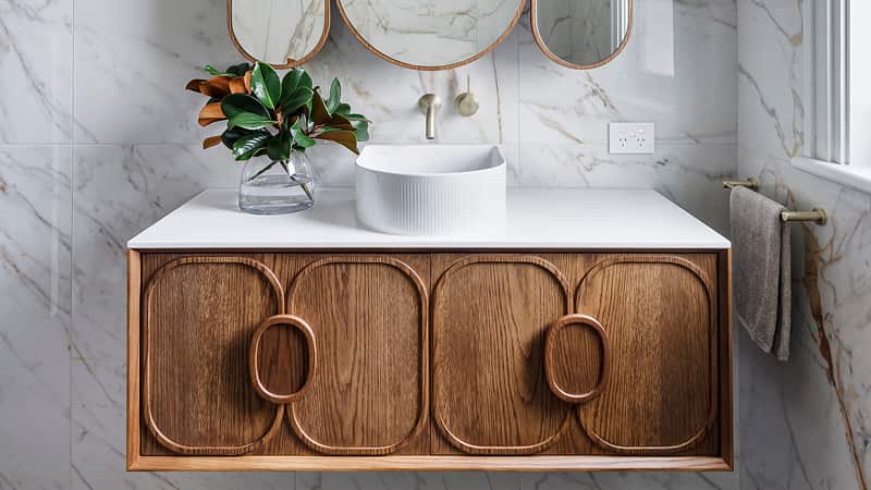 Contemporary bathroom with marble walls and a wooden vanity
