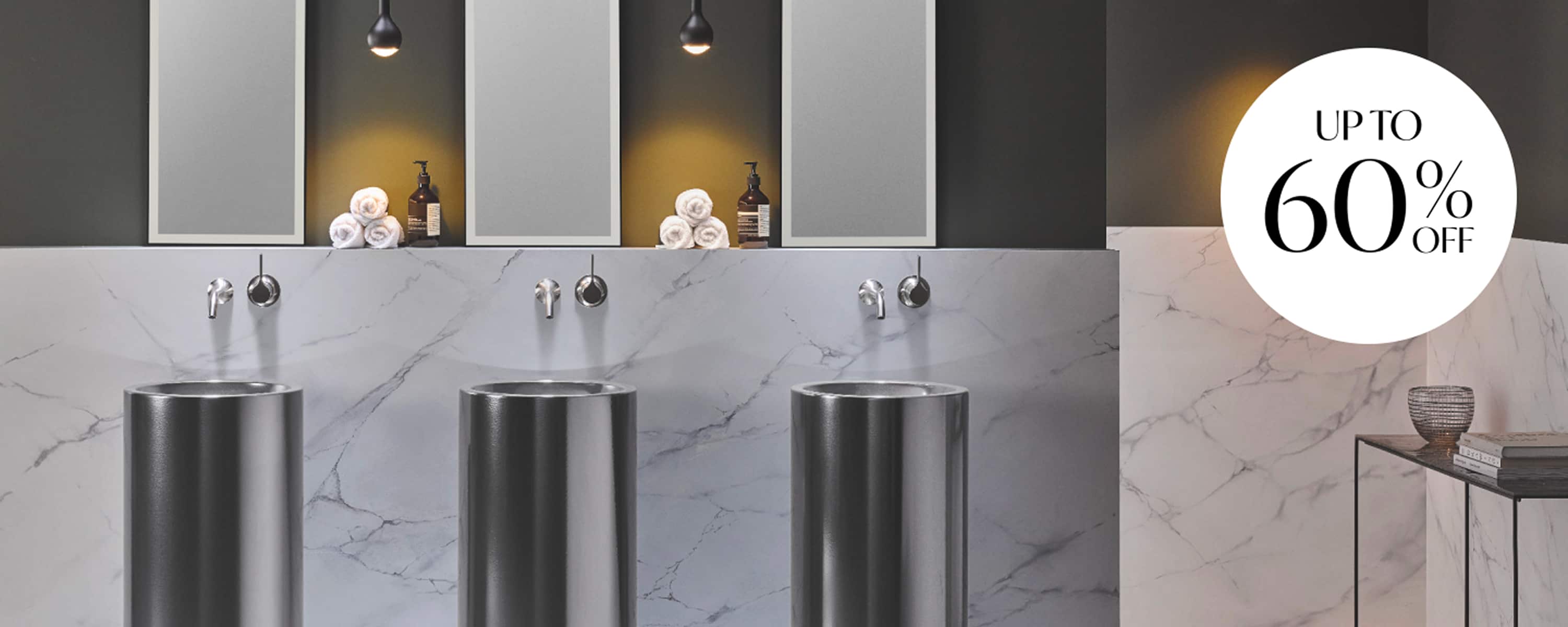 Three black pedestal basins in a row on a marble wall, with three mirrors and and accessories