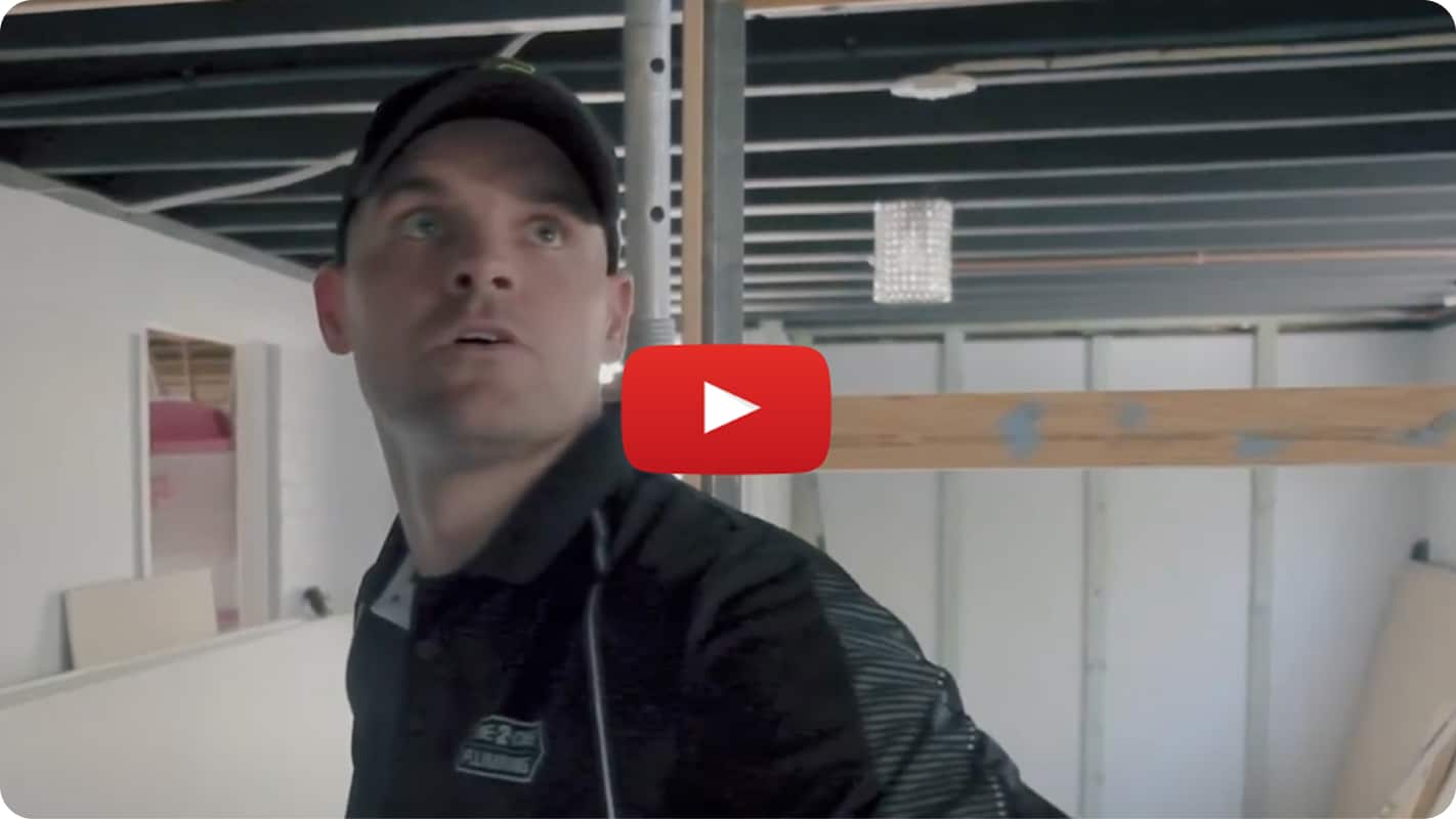 A still of a YouTube video, featuring a plumber looking at something on the ceiling.