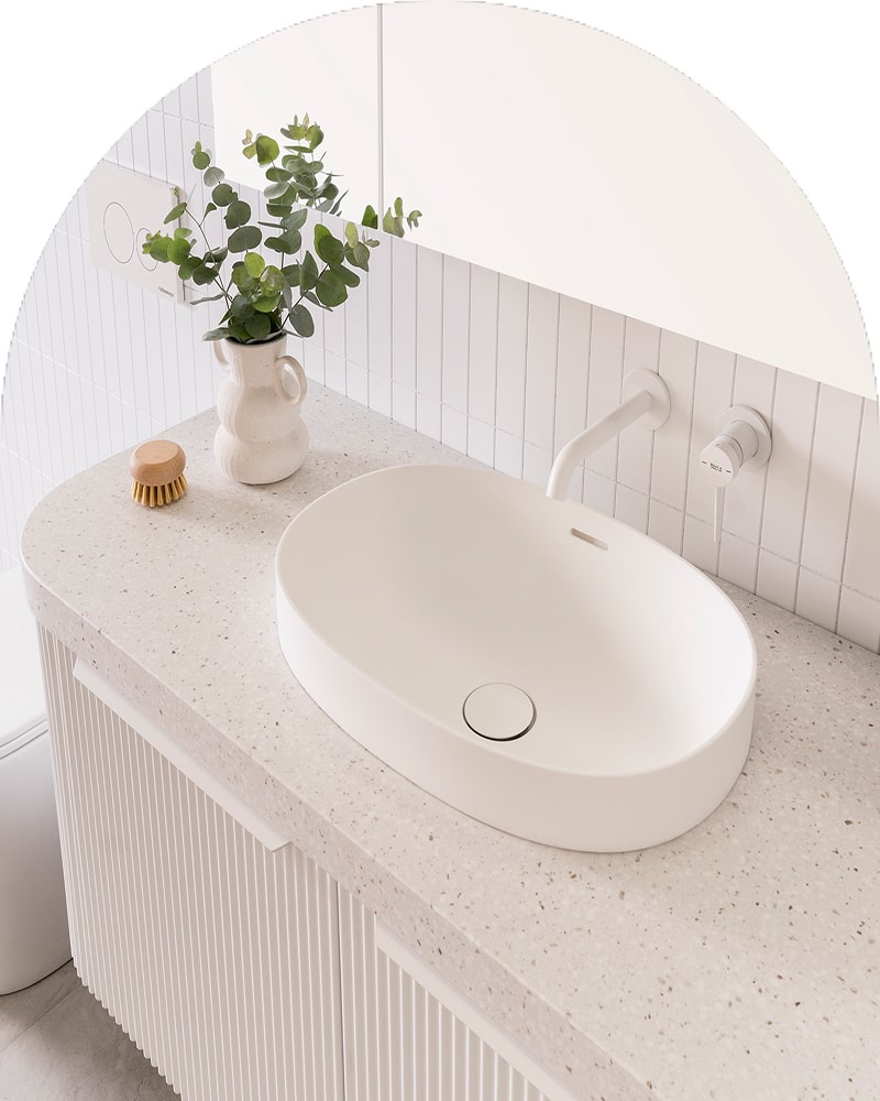 A bright bathroom featuring a white basin and white tapware.