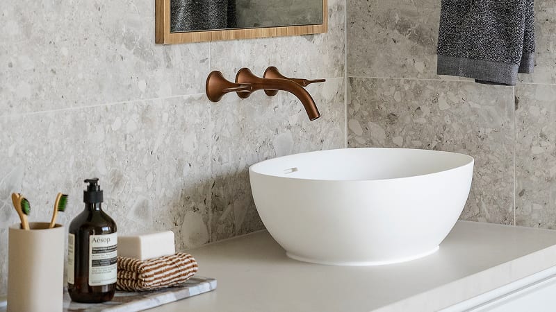 A modern, white bathroom basin paired with a stylish, matte dark metal tapware.
