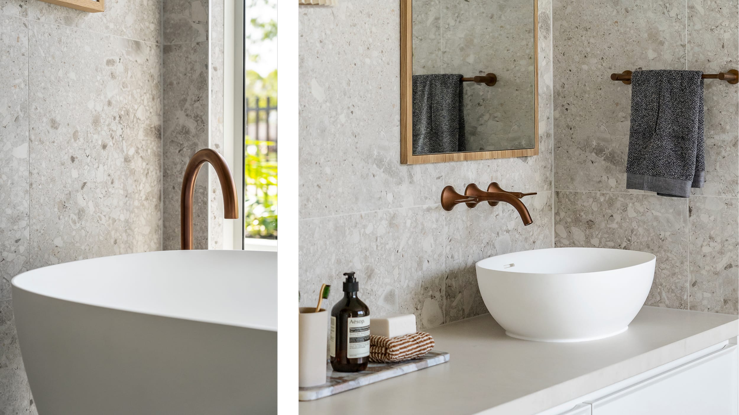 A freestanding, white bathtub located in front of a window, creating a bright and airy atmosphere in the bathroom, paired with a dark, brushed metal floor mounted tap.