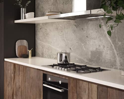 A kitchen bench, including oven, stovetop and rangehood, against a grey marble wall