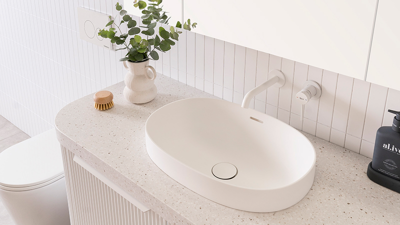 A bright bathroom featuring a white basin and white tapware.