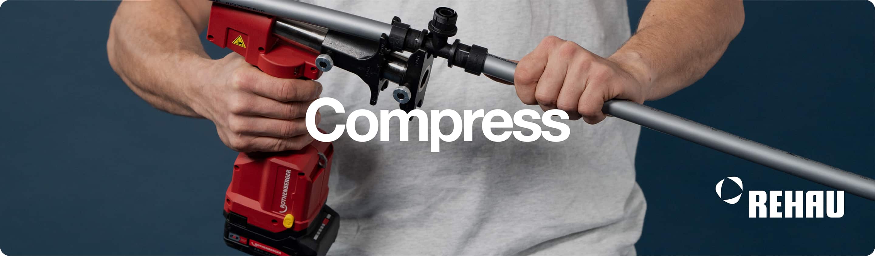 A tradesman in a white shirt, compressing Rehau PEX pipe with a hand tool.