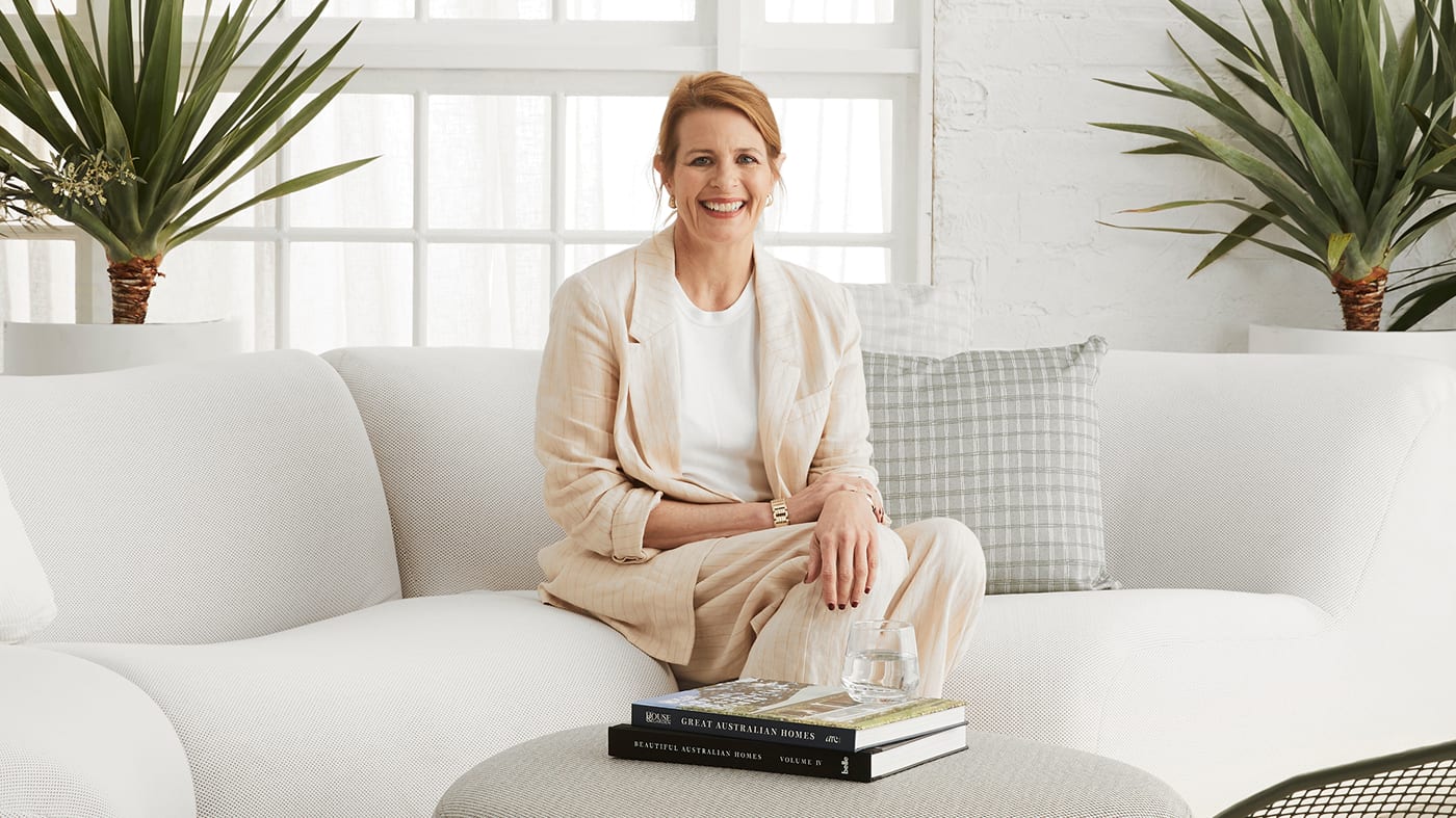 Australian House and Garden editor-in-chief Tanya Buchanan smiling to camera, sitting on a sofa