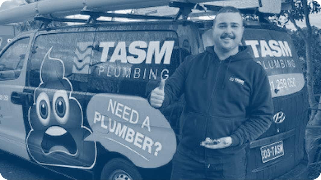 A plumber standing in front of a work van, giving a thumbs up.