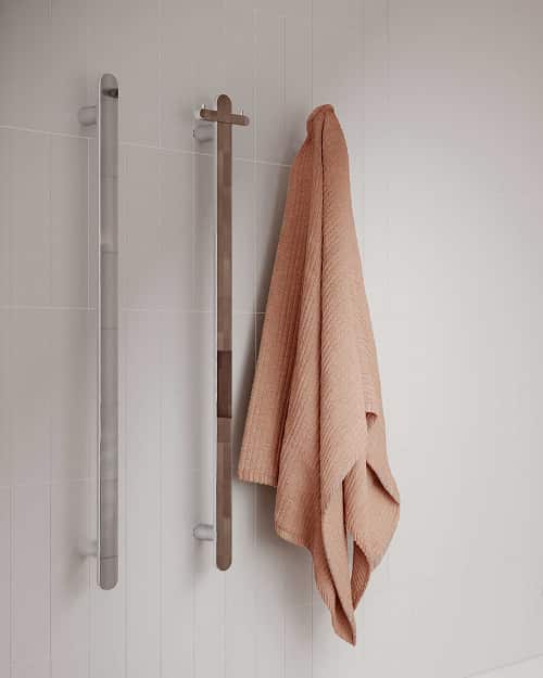 Three vertical towel rails, one with a pink towel