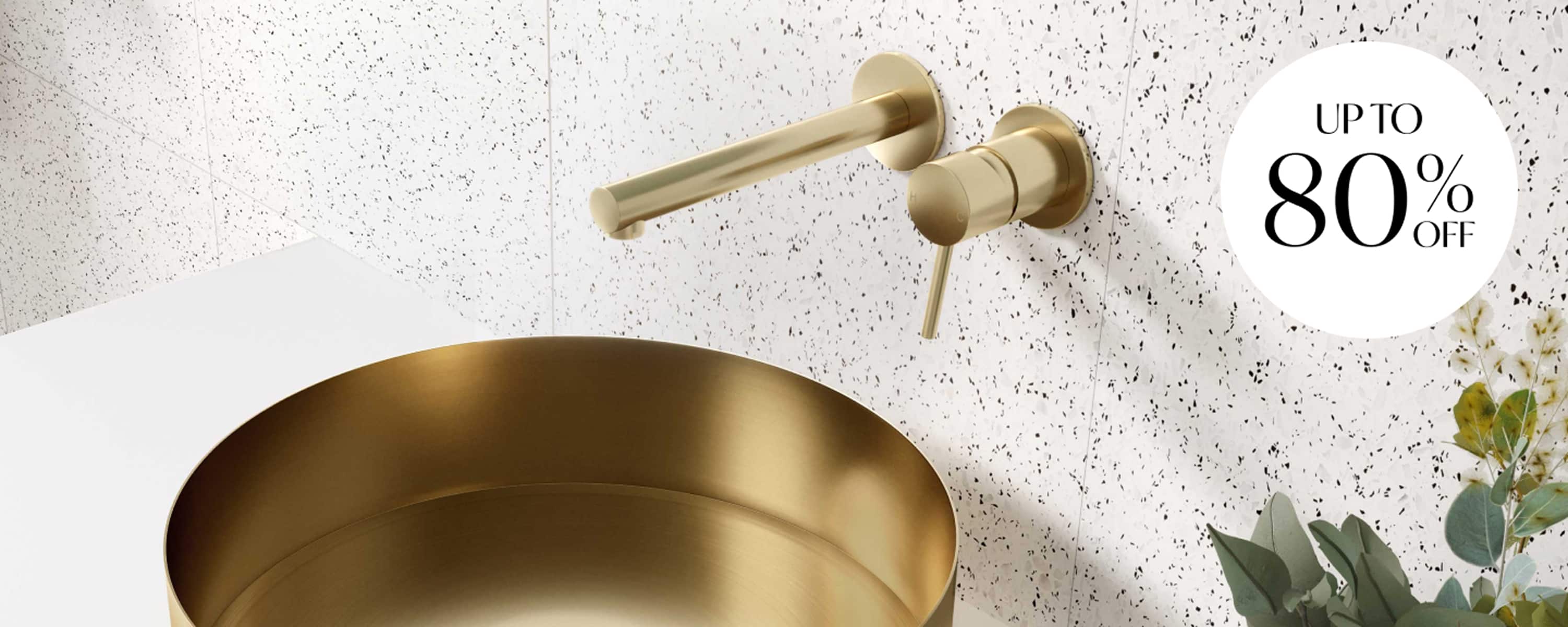 A gold basin and gold tapware in a light, white bathroom